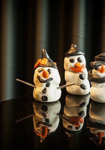 Trois bonshommes de neige en plasticine sur un piano